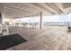 Open-air deck with multiple tables and chairs, a wooden floor, and a partial view of the surrounding landscape at 330 Concord St # 2F, Charleston, SC 29401