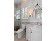 Modern bathroom with tiled shower, marble countertop, round mirror, stylish vanity, and window with plantation shutters at 332 Bayley Rd, Daniel Island, SC 29492
