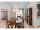 Formal dining room with a wooden table and chairs, decorative chandeliers, and blue accents at 332 Bayley Rd, Daniel Island, SC 29492