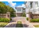 Brick driveway leading to garages, with a well-maintained lawn and verdant landscaping at 332 Bayley Rd, Daniel Island, SC 29492
