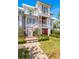 Charming two-story home with a well-manicured lawn, brick pathway, and inviting front porch with classic columns at 332 Bayley Rd, Daniel Island, SC 29492