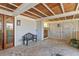 Covered carport with brick flooring, a bench, wooden doors, and a view of the lush greenery at 332 Bayley Rd, Daniel Island, SC 29492