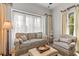 Cozy living room featuring a comfortable sofa, armchair, ottoman, and large window with bright natural light at 332 Bayley Rd, Daniel Island, SC 29492