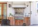 Well equipped outdoor kitchen featuring wood cabinets, a granite backsplash, and a stainless steel grill and hood at 332 Bayley Rd, Daniel Island, SC 29492