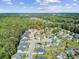 An aerial view of a neighborhood with manicured lawns and cul-de-sacs surrounded by lush trees, under a partly cloudy sky at 3801 Canary Ct, North Charleston, SC 29420