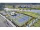 Aerial view showcases community pickleball courts and a pond nestled within new construction homes at 383 Oak Park St, Summerville, SC 29486
