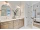 Elegant bathroom with double vanity, arched mirrors, decorative lights, and an open door to a bedroom at 503 Ivy Green Ln, Summerville, SC 29486