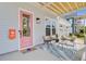 Close up of a cozy front porch with stylish furniture and a vibrant pink door at 503 Ivy Green Ln, Summerville, SC 29486