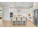 Bright kitchen features white cabinets, stainless steel appliances, pendant lighting, and a large island with seating at 503 Ivy Green Ln, Summerville, SC 29486