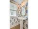 Stylish powder room featuring patterned wallpaper, pedestal sink, and gold fixtures and mirror at 503 Ivy Green Ln, Summerville, SC 29486