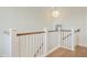 Upstairs hallway with white trim, wood railings, and hardwood floors featuring views of home interior at 503 Ivy Green Ln, Summerville, SC 29486