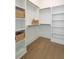 Bright walk-in closet with custom shelves, wooden rods, and hardwood floors offers lots of storage space at 503 Ivy Green Ln, Summerville, SC 29486