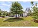 Landscaped backyard featuring a grassy lawn and mature tree enhancing curb appeal at 512 Pontoon Rd, Huger, SC 29450