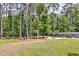 A large backyard with lush, mature trees, a garden, a fire pit, and mature landscaping at 512 Pontoon Rd, Huger, SC 29450