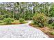 Backyard with lush trees, beautiful garden, and lovely landscaping with pavers leading to a fire pit at 512 Pontoon Rd, Huger, SC 29450
