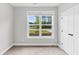 Cozy bedroom with neutral carpet, white trim, and a bright window overlooking the front yard at 512 Pontoon Rd, Huger, SC 29450