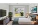 Inviting bedroom with a green accent wall, hardwood floors, and a large window overlooking the backyard at 512 Pontoon Rd, Huger, SC 29450