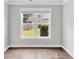 Empty room with hardwood floors, white trim, and a large window with a view to the backyard at 512 Pontoon Rd, Huger, SC 29450