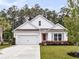 Charming one-story home featuring a well-manicured lawn, white exterior, and a bright pink front door at 512 Pontoon Rd, Huger, SC 29450