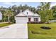 Beautiful one-story home boasting lush green lawns, palm tree, and clean white exterior with pink front door at 512 Pontoon Rd, Huger, SC 29450