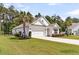 Image of a white, one-story home with a two-car garage, green lawn, and pink front door, palm trees at 512 Pontoon Rd, Huger, SC 29450