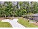 Stone fire pit with walkway, mature landscaping, and a garden in the backyard of this beautiful home at 512 Pontoon Rd, Huger, SC 29450