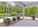 An outdoor screened porch gives relaxing backyard views with luscious landscaping and greenery at 512 Pontoon Rd, Huger, SC 29450