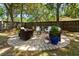 Backyard features a circular stone paver patio seating area with potted plants, a firepit, and wooden fence at 520 Yale Dr, Charleston, SC 29412
