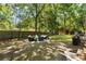 Private backyard with a patio seating area, a wooden fence, and mature trees providing shade at 520 Yale Dr, Charleston, SC 29412
