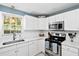 Well-lit kitchen features white cabinets, stainless steel appliances, and a window providing natural light at 520 Yale Dr, Charleston, SC 29412