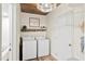Well-lit laundry room features a washer, dryer, and rustic wooden shelf with decorations at 520 Yale Dr, Charleston, SC 29412