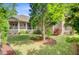 Well maintained backyard with brick home, covered porch, lush lawn, and mature landscaping at 5433 Clearview Dr, North Charleston, SC 29420