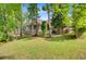 Expansive backyard with lush green lawn, mature trees and the home's covered porch at 5433 Clearview Dr, North Charleston, SC 29420