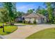 Well-maintained brick house showcasing a side-entry garage and colorful flowering bushes at 5433 Clearview Dr, North Charleston, SC 29420