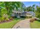 A home with an arched entryway, a circular driveway, and professional landscaping at 5433 Clearview Dr, North Charleston, SC 29420