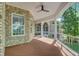 Covered porch with brick facade and wood look floors, ceiling fan, and scenic view at 5433 Clearview Dr, North Charleston, SC 29420