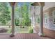 Covered porch with white columns and railing overlooking lush greenery and professional landscaping at 5433 Clearview Dr, North Charleston, SC 29420