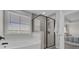 Bright bathroom with a combination tub and shower featuring tile surround and black framed glass door at 661 Black Pine Rd, Moncks Corner, SC 29461