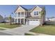 Charming two-story home featuring a welcoming front porch, two car garage and nicely kept lawn at 661 Black Pine Rd, Moncks Corner, SC 29461
