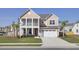 Charming two-story home featuring a welcoming front porch, two car garage and freshly manicured lawn at 661 Black Pine Rd, Moncks Corner, SC 29461