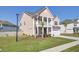 Charming two-story home featuring a welcoming front porch, two car garage and freshly manicured lawn at 661 Black Pine Rd, Moncks Corner, SC 29461