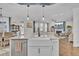 Open-concept kitchen with white cabinets, stainless dishwasher, farmhouse sink, and seating overlooking the living space at 661 Black Pine Rd, Moncks Corner, SC 29461