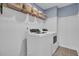 Laundry room with white front-loading washer and dryer, shelving, and tiled floors at 661 Black Pine Rd, Moncks Corner, SC 29461