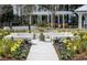 Beautiful garden with a charming fountain, colorful flowers, and white benches under a white pergola at 774 Clay Field Trl, Summerville, SC 29485