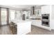 Modern kitchen with stainless steel appliances, large center island, and sleek white cabinetry at 786 Clay Field Trl, Summerville, SC 29485