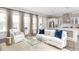 Bright and airy living room open to the kitchen, featuring a plush white sofa and ample natural light at 786 Clay Field Trl, Summerville, SC 29485