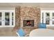 Outdoor brick fireplace with burning logs, with view of the patio with tables and chairs at 7896 Montview Rd, North Charleston, SC 29418