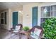 Inviting porch with two chairs, decorative pillows, and teal front door at 7896 Montview Rd, North Charleston, SC 29418