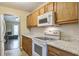 Well-lit kitchen featuring wooden cabinets, modern appliances, and view to the living room at 7896 Montview Rd, North Charleston, SC 29418