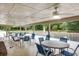 Covered outdoor seating area with tables, chairs, and a view of a serene pond with a fountain at 7896 Montview Rd, North Charleston, SC 29418
